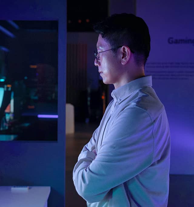 Dr. Yoo is looking at Bendable Gaming OLED display with his arms crossed.