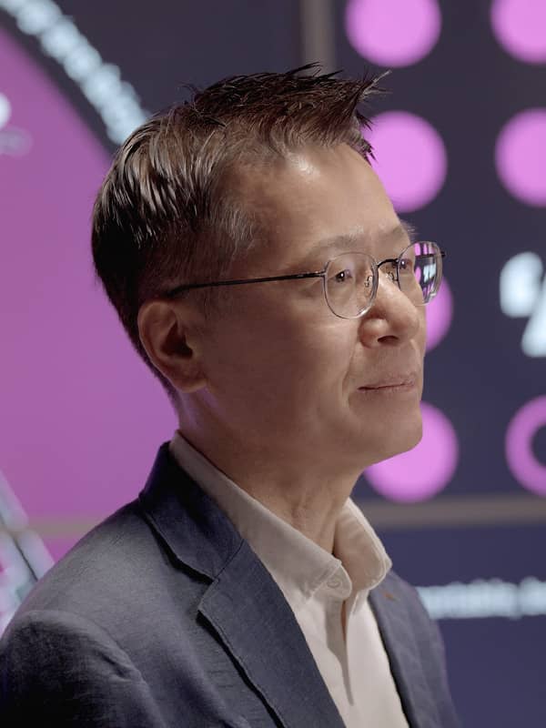 Mr. Kim is smiling while sitting in the background of a Transparent OLED show window with purple lighting.